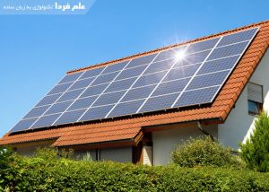 Solar panel on a red roof reflecting the sun and the cloudless blue sky